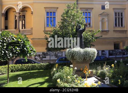 Cracow. Krakow. Poland. The palace of archbishop of Cracow. Bishop`s curial offices headquarters. The statue of late pope John Paul II, aka Karol Wojt Stock Photo